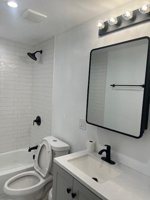 bathroom featuring tub / shower combination, toilet, and vanity