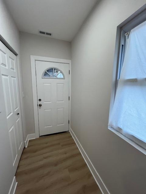 entryway featuring wood finished floors, visible vents, and baseboards