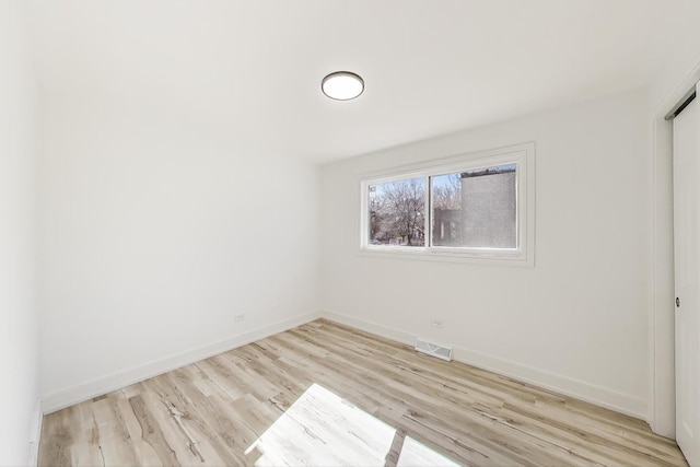 interior space with wood finished floors, baseboards, and visible vents