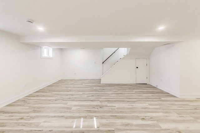 basement with stairway, baseboards, and light wood-type flooring