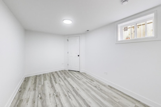 unfurnished room featuring baseboards and light wood finished floors