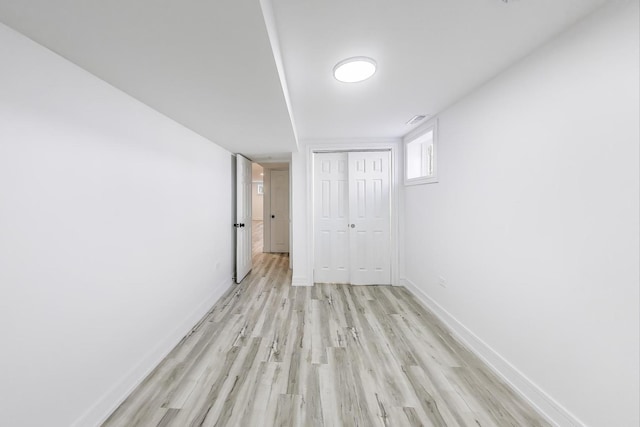 empty room featuring visible vents, light wood-style flooring, and baseboards