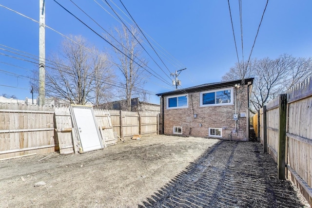 exterior space featuring brick siding and a fenced backyard