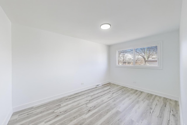 unfurnished room with visible vents, light wood-style floors, and baseboards