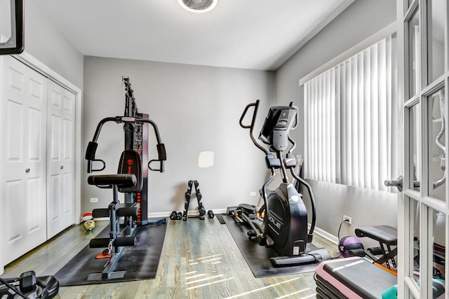 workout room featuring visible vents, baseboards, and wood finished floors