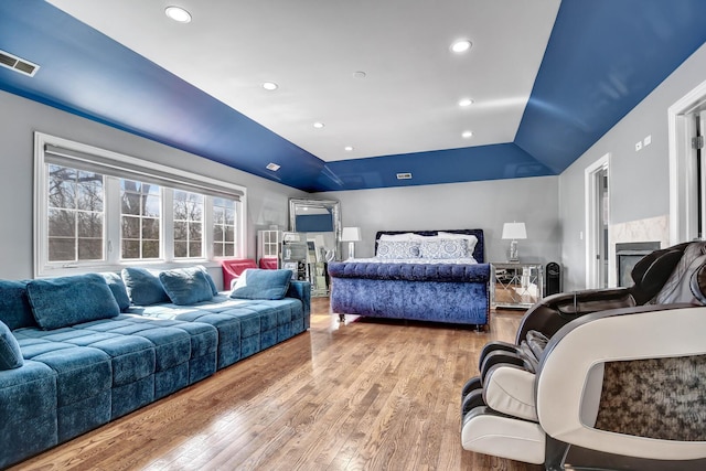 bedroom with visible vents, recessed lighting, a raised ceiling, and wood finished floors