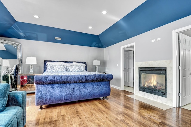 bedroom with light wood finished floors, visible vents, baseboards, recessed lighting, and a fireplace