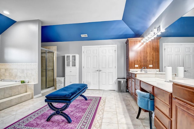 bathroom featuring lofted ceiling, a garden tub, a stall shower, and vanity