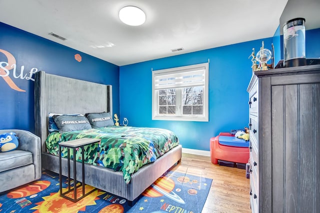 bedroom featuring wood finished floors, visible vents, and baseboards