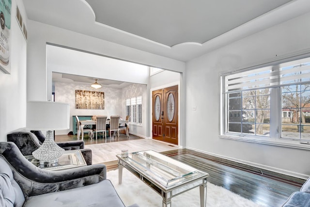 living room with baseboards, plenty of natural light, and wood finished floors