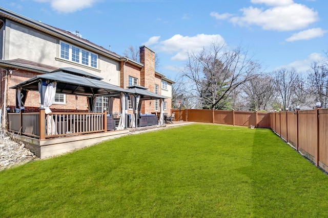 view of yard featuring a gazebo, a wooden deck, and a fenced backyard