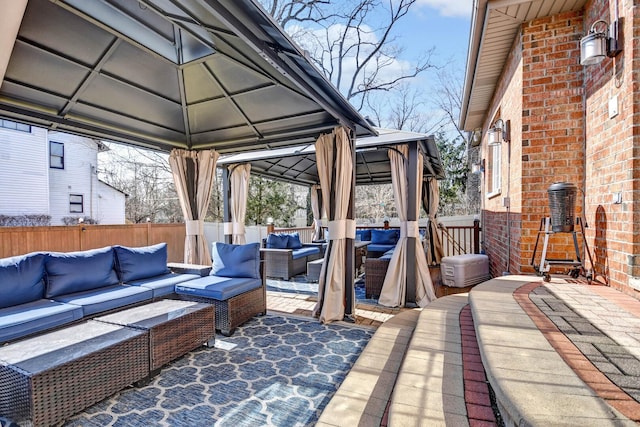 view of patio / terrace with a gazebo, outdoor lounge area, and fence