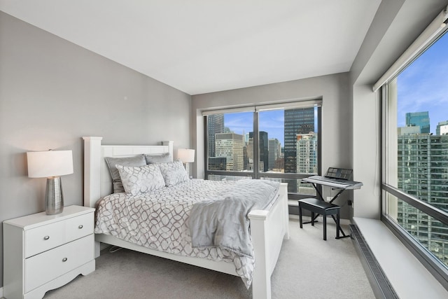 bedroom featuring light carpet and a view of city