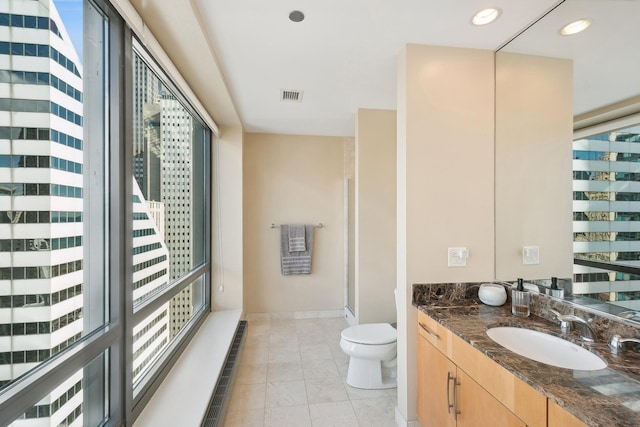 full bathroom featuring vanity, visible vents, recessed lighting, walk in shower, and toilet