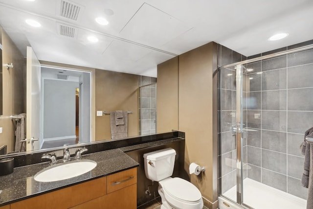 full bath featuring vanity, a shower stall, toilet, and visible vents