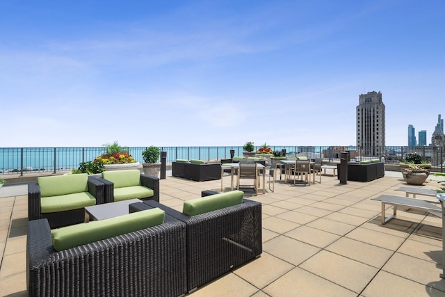 view of patio / terrace featuring an outdoor living space, a water view, and a view of city