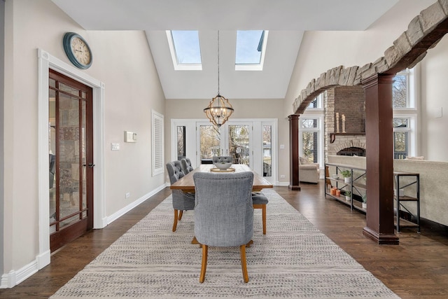 dining space with dark wood finished floors, baseboards, and an inviting chandelier