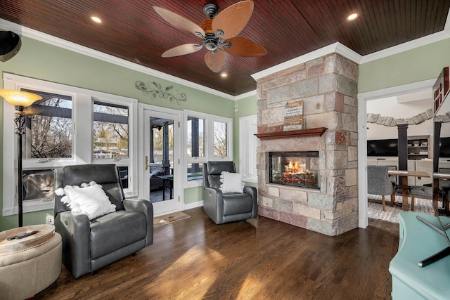 living area with a fireplace, wood finished floors, wood ceiling, and ornamental molding