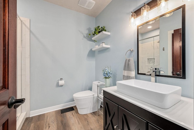 bathroom with a shower with door, visible vents, baseboards, toilet, and wood finished floors