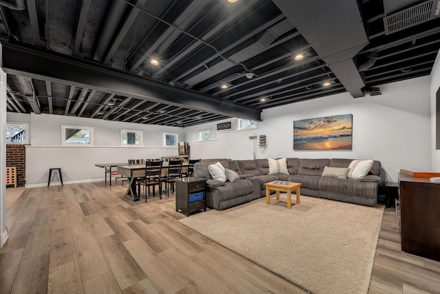 living room with light wood finished floors, visible vents, and baseboards