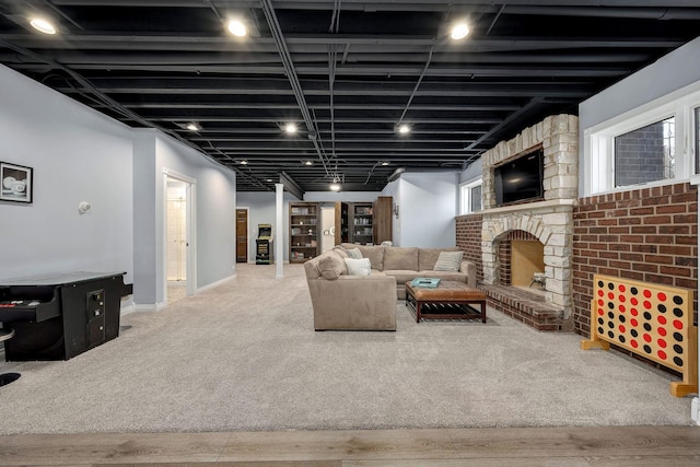 living area with a brick fireplace, carpet flooring, and baseboards