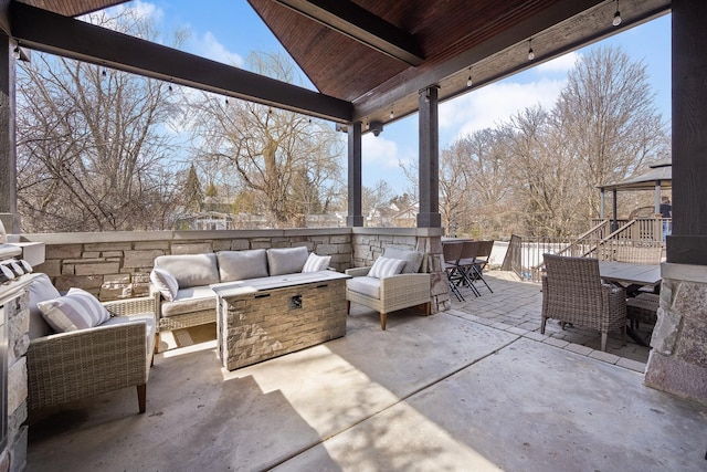 view of patio with an outdoor living space with a fire pit and outdoor dining area