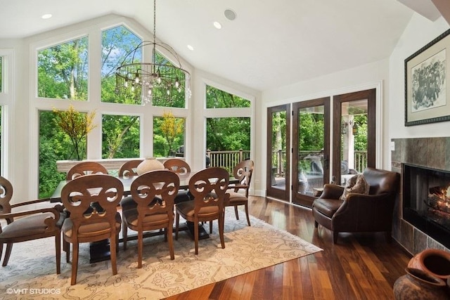 sunroom / solarium with a premium fireplace, a chandelier, and vaulted ceiling