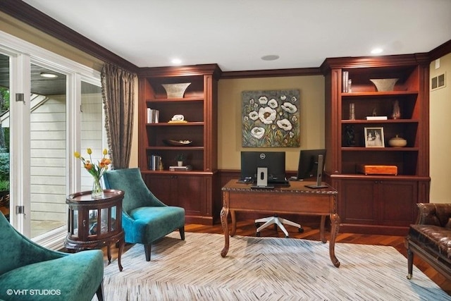 office area featuring wood finished floors, visible vents, and ornamental molding