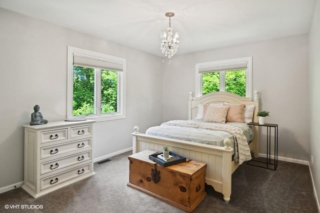 carpeted bedroom featuring a notable chandelier, visible vents, multiple windows, and baseboards