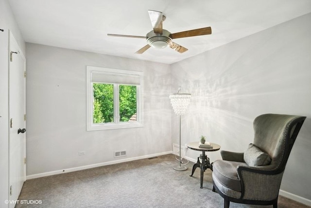 living area featuring visible vents, baseboards, carpet, and ceiling fan