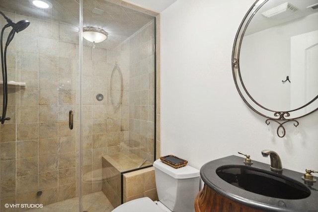 bathroom featuring toilet, visible vents, and a stall shower