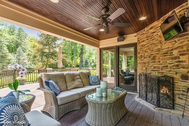 deck with an outdoor living space and a ceiling fan