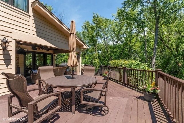 deck with outdoor dining space and a ceiling fan