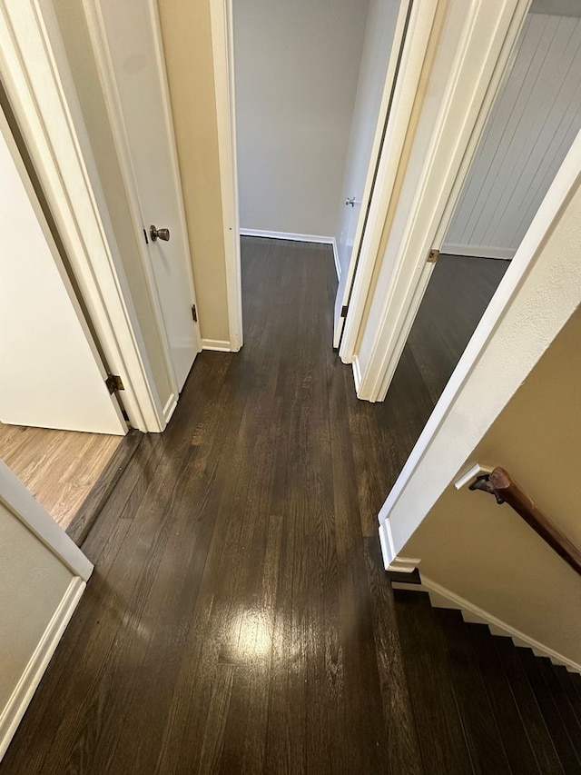 hallway featuring baseboards and dark wood-style floors