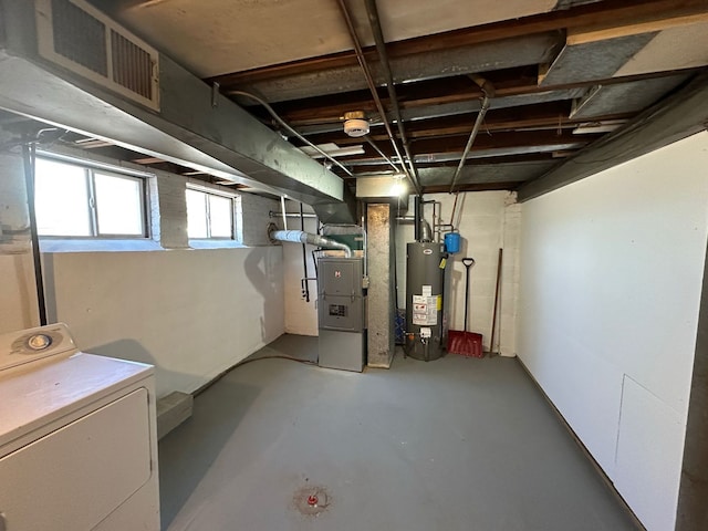 below grade area featuring heating unit, washer / dryer, and water heater