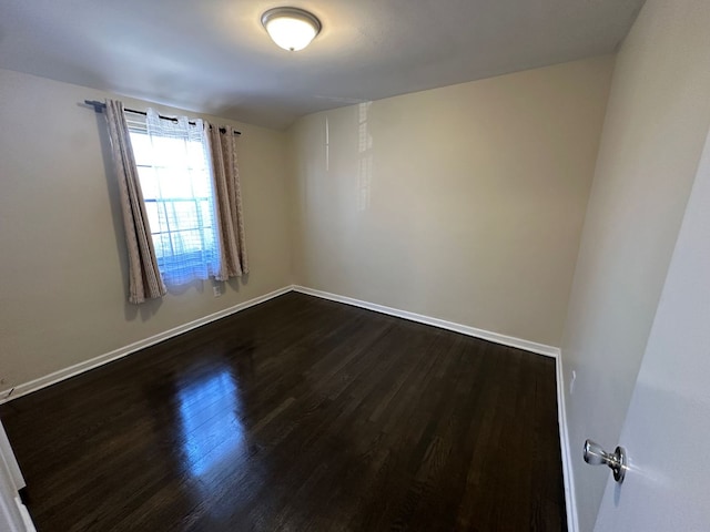 empty room with baseboards and dark wood-style flooring