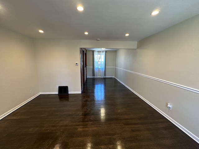 spare room with recessed lighting, baseboards, and wood finished floors