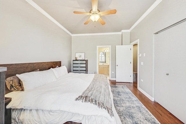 bedroom with baseboards, ornamental molding, ensuite bathroom, wood finished floors, and a ceiling fan