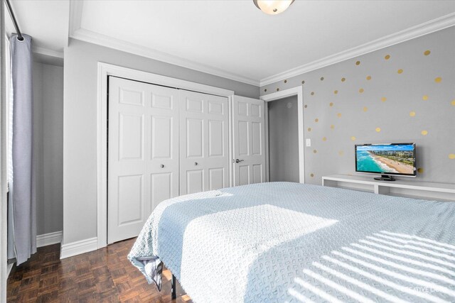 bedroom with a closet, baseboards, and ornamental molding