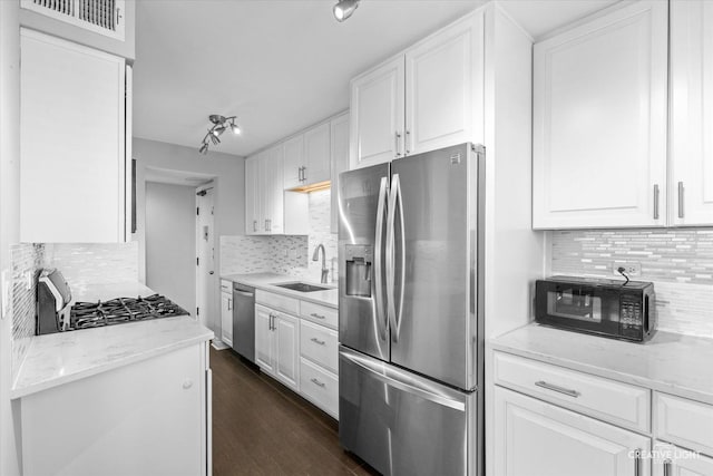 kitchen featuring dark wood-style floors, appliances with stainless steel finishes, white cabinetry, and a sink