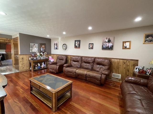 living area with wood finished floors, visible vents, a wainscoted wall, recessed lighting, and wood walls