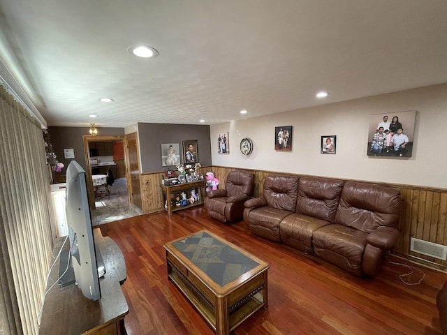 living room featuring wooden walls, recessed lighting, wood finished floors, and a wainscoted wall