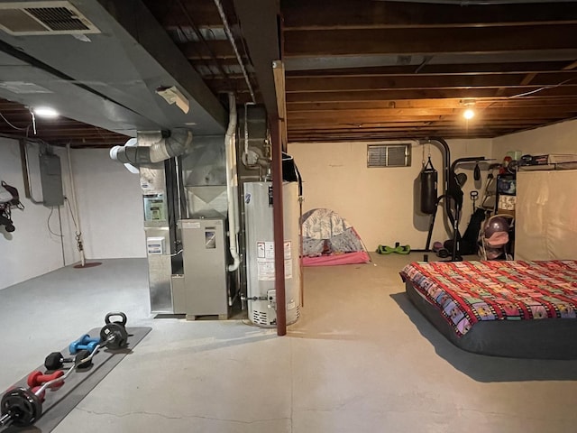 unfinished basement with water heater, visible vents, and electric panel