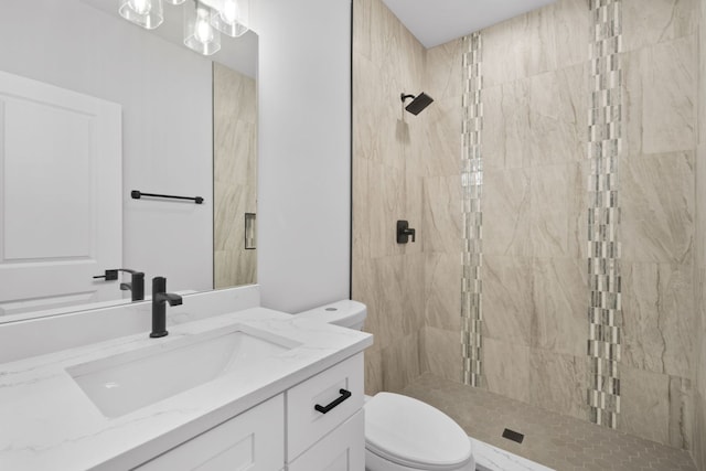 bathroom with tiled shower, toilet, and vanity