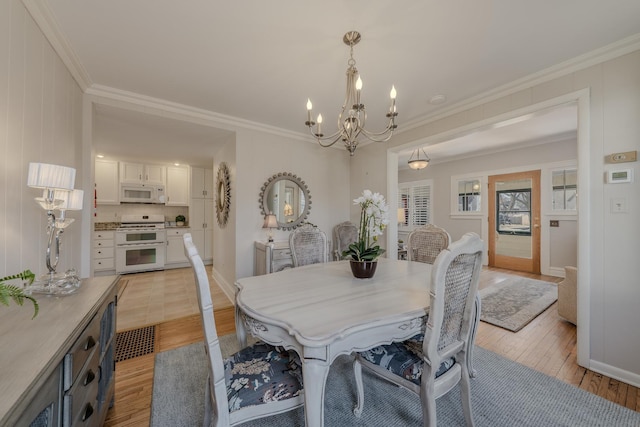 421 Dodson St, Geneva, IL 60134 - dining space featuring light wood-style floors, a chandelier, and ornamental molding