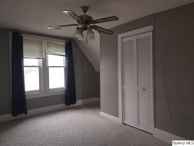 bonus room featuring ceiling fan, baseboards, carpet floors, and a textured ceiling