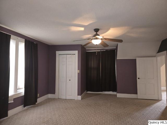 unfurnished bedroom featuring baseboards, light colored carpet, and a ceiling fan