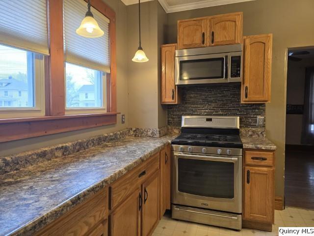 kitchen featuring brown cabinets, decorative light fixtures, backsplash, stainless steel appliances, and crown molding