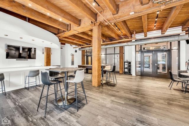 dining area with beamed ceiling, french doors, rail lighting, and wood finished floors