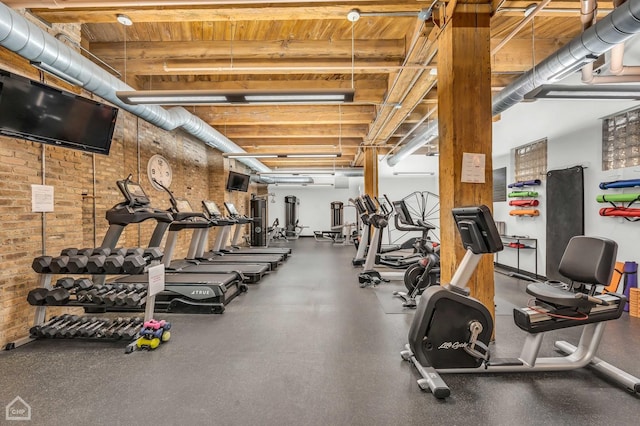 exercise room featuring brick wall